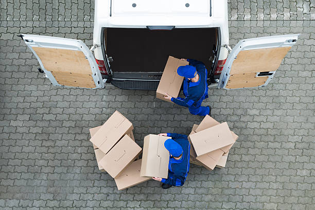 Directly above shot of delivery men unloading cardboard boxes from truck on street