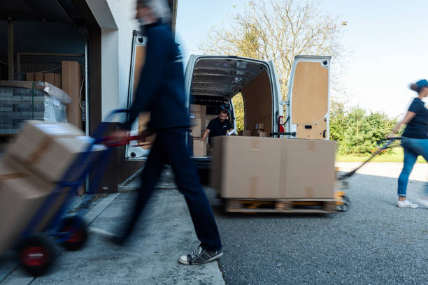 Delivery Men Unloading Cardboard Boxes From delivery van